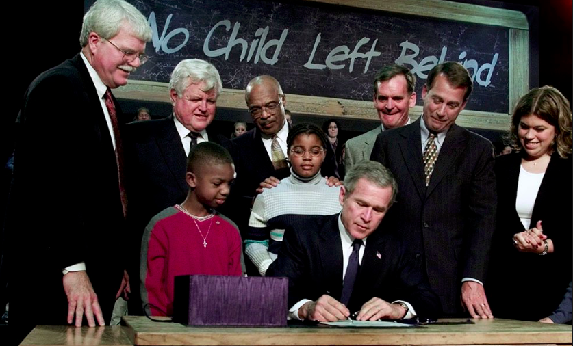No Child Left Act Signing Ceremony (President George W. Bush signing bill into law, surrounded by John Boehner, Ted Kennedy and school-age students). 